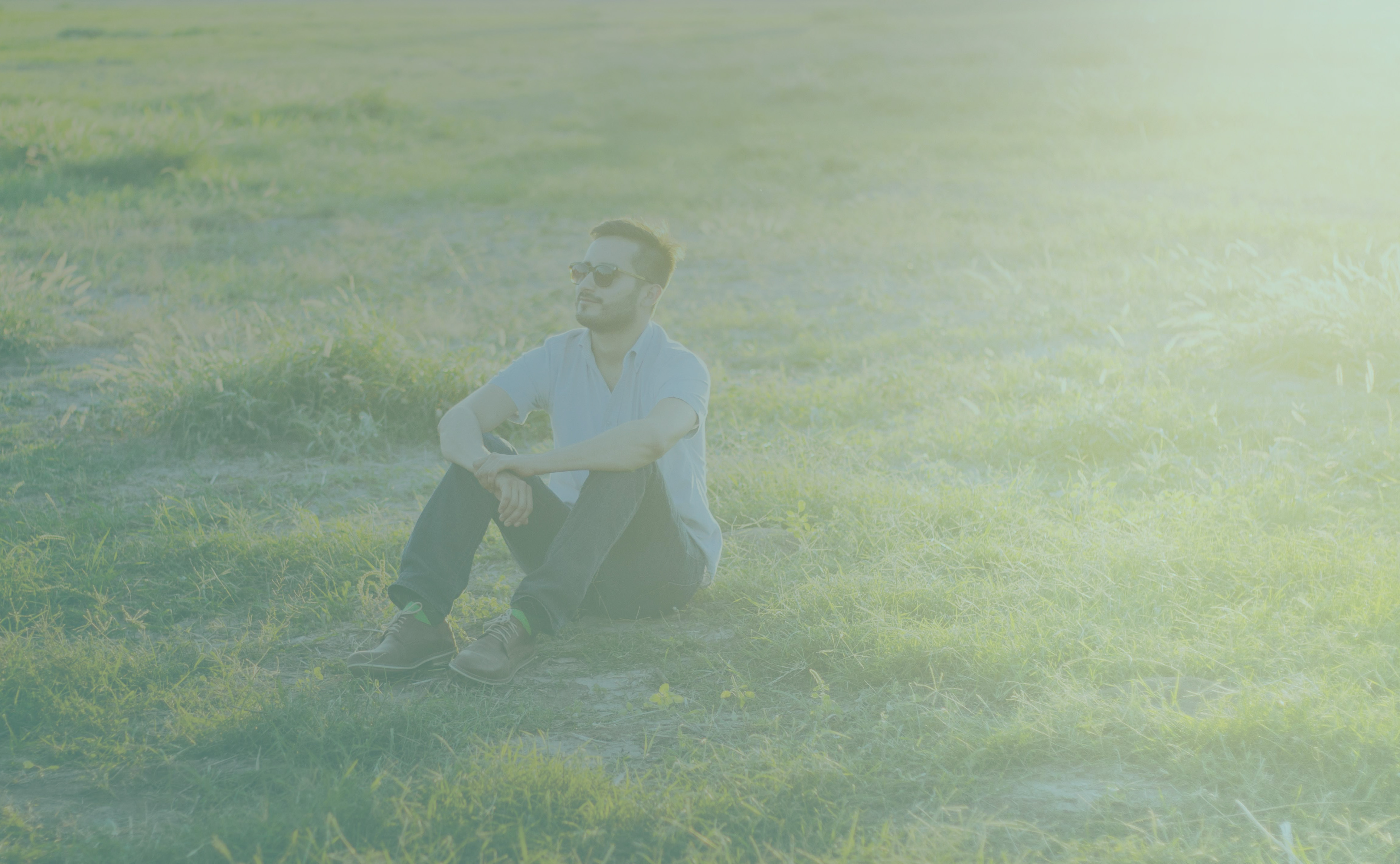 Homme heureux assis sur la pelouse